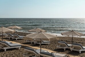 On the beach, black sand, beach towels - Amaria Beach Resort (Santorini)