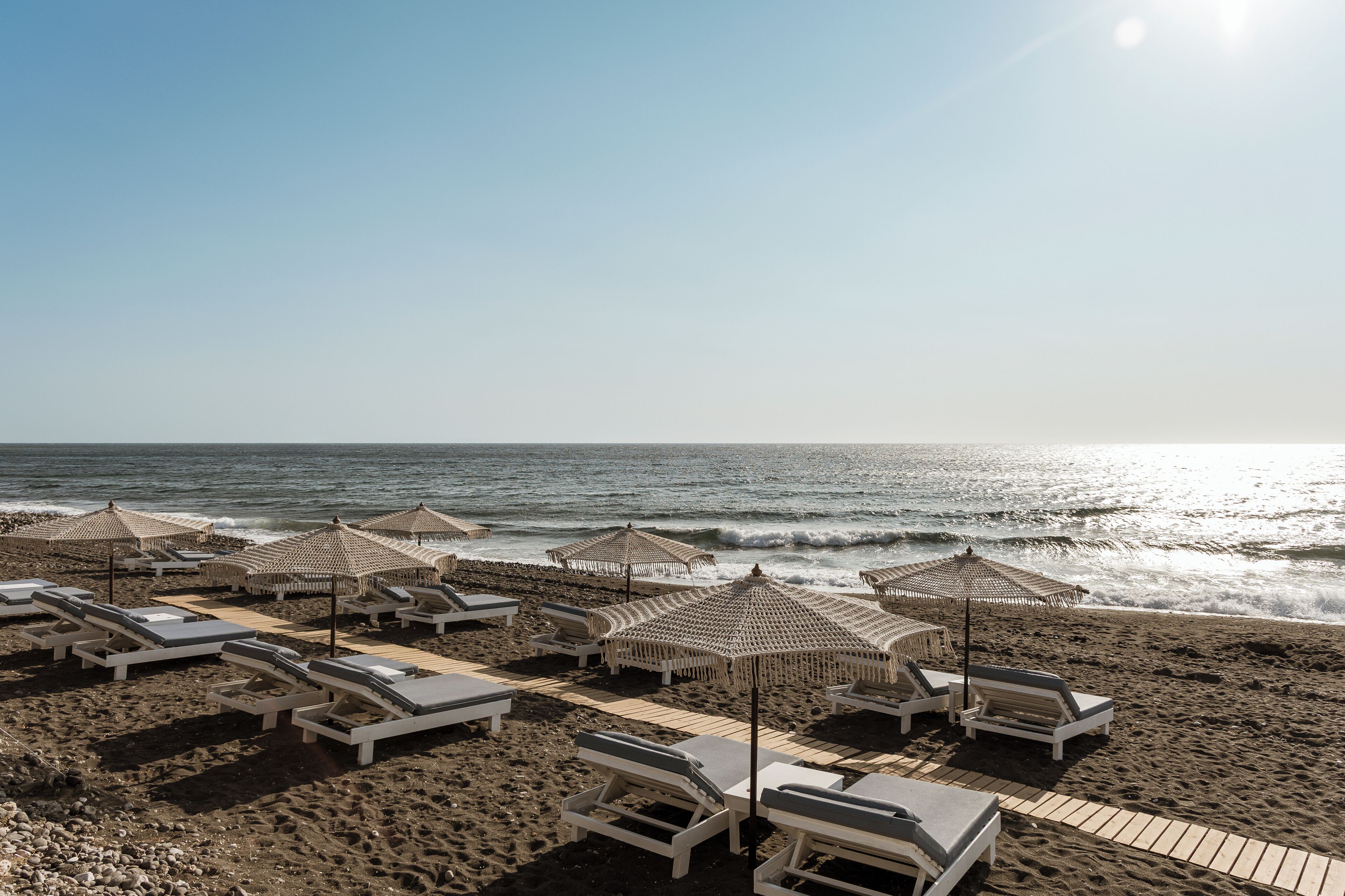 on the beach, black sand, beach towels