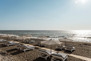 Am Strand, schwarzer Sandstrand, Strandtücher