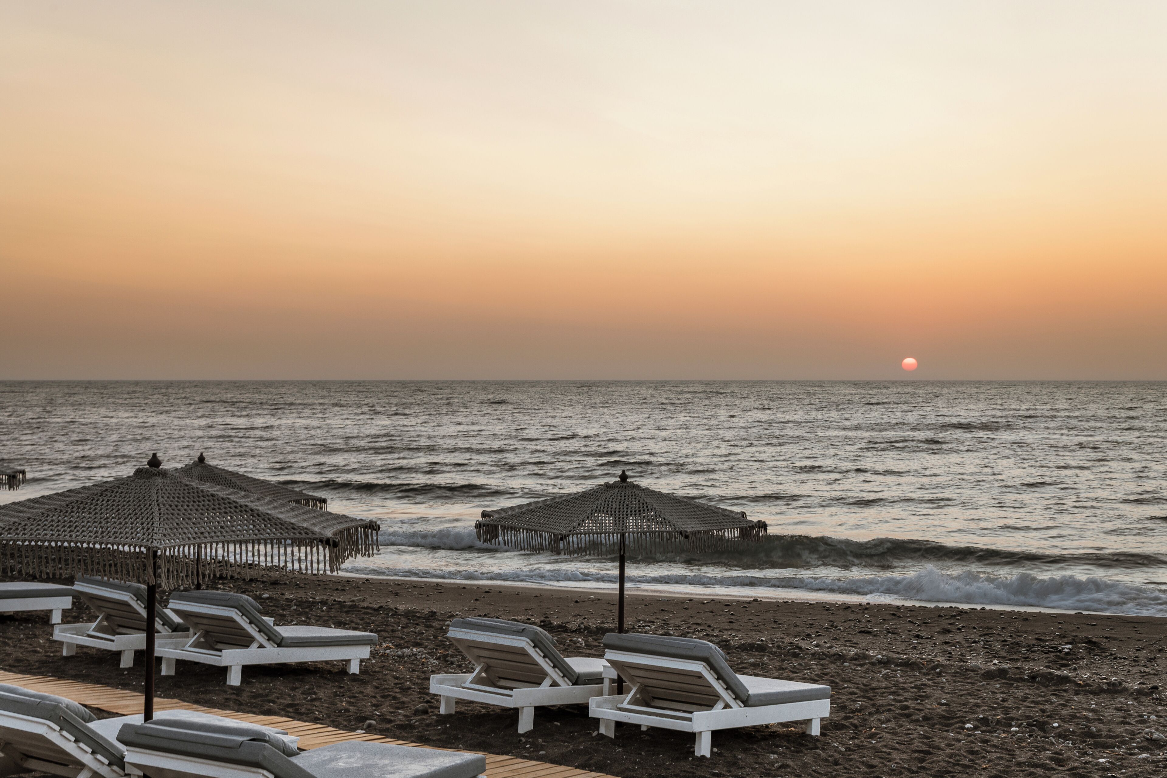 on the beach, black sand, beach towels