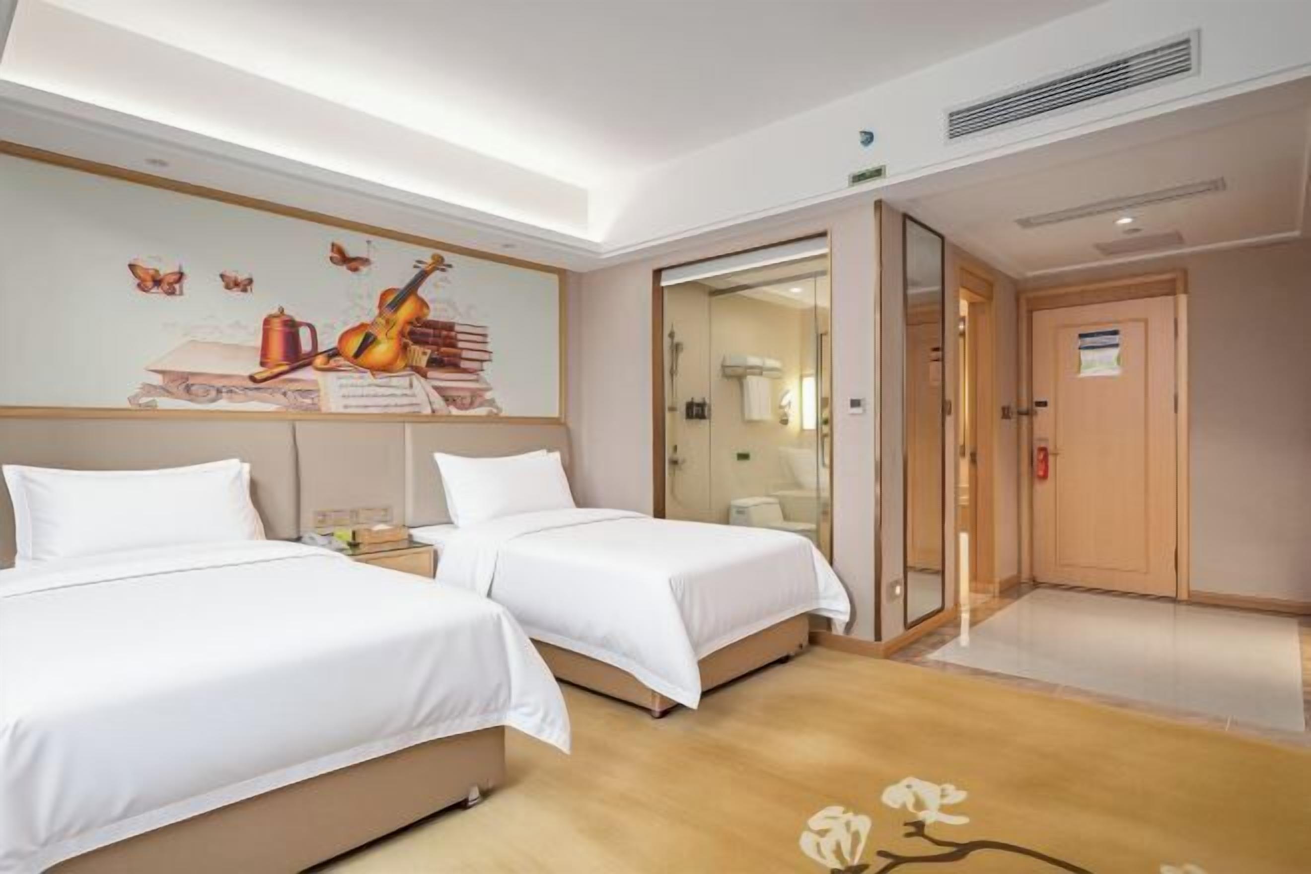 Une chambre d’hôtel avec deux lits, une fresque murale et un plancher en bois.