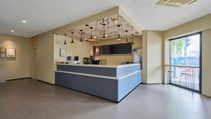 Uma área de recepção moderna com balcão, detalhes no teto e uma grande janela.