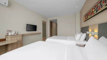 Habitación de hotel con dos camas, un televisor, un escritorio con cafetera y un cuadro en la pared.