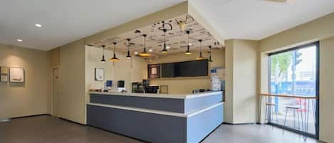 A reception area with a counter, ceiling lights, and a large window.