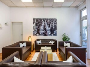Una sala de estar moderna con sofás de cuero, una mesa de centro y una gran obra de arte en blanco y negro en la pared.