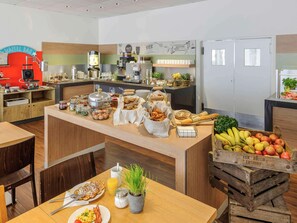 En morgenmadsbuffet med forskellige spiser og en kaffestation.