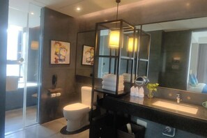 A modern bathroom with a glass shower enclosure, a large mirror, and a black vanity. - Tianyuan Mingyue Hotel (Jingning)