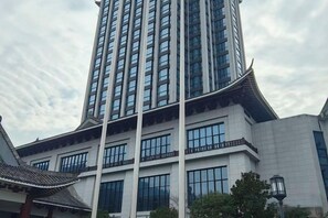 A modern building with a traditional architectural style, featuring a prominent tower and large windows. - Tianyuan Mingyue Hotel (Jingning)