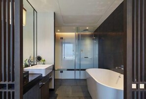 A modern bathroom with a large bathtub, a glass shower enclosure, and a vanity with a mirror. - Tianyuan Mingyue Hotel (Jingning)