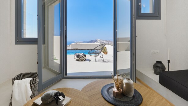 Et moderne værelse med en stor skydedør, der fører ud til en balkon med swimmingpool og udendørs møbler.