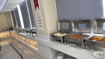 A buffet setup with various food items and utensils.