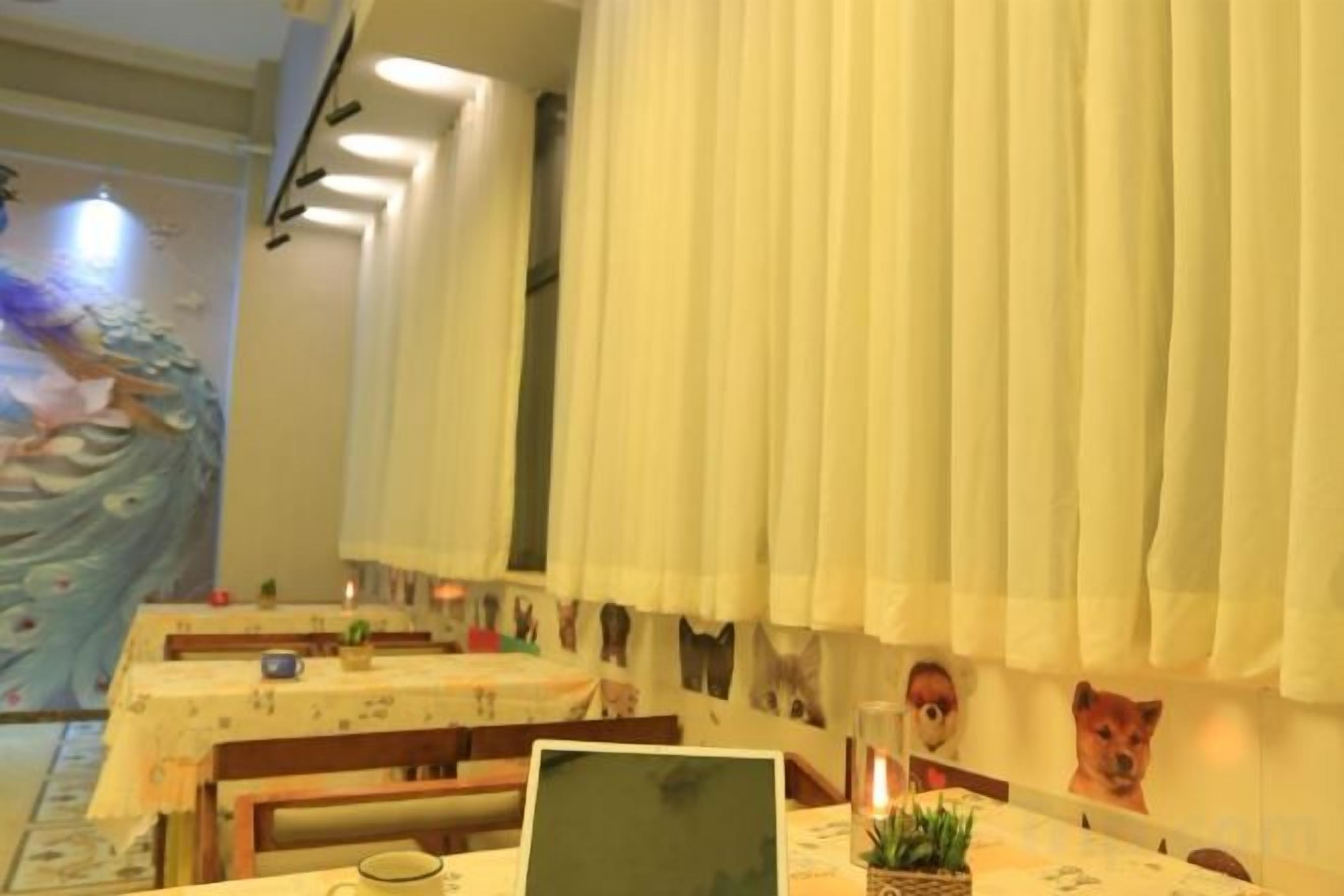 A dining area with tables, chairs, and a laptop on one table.