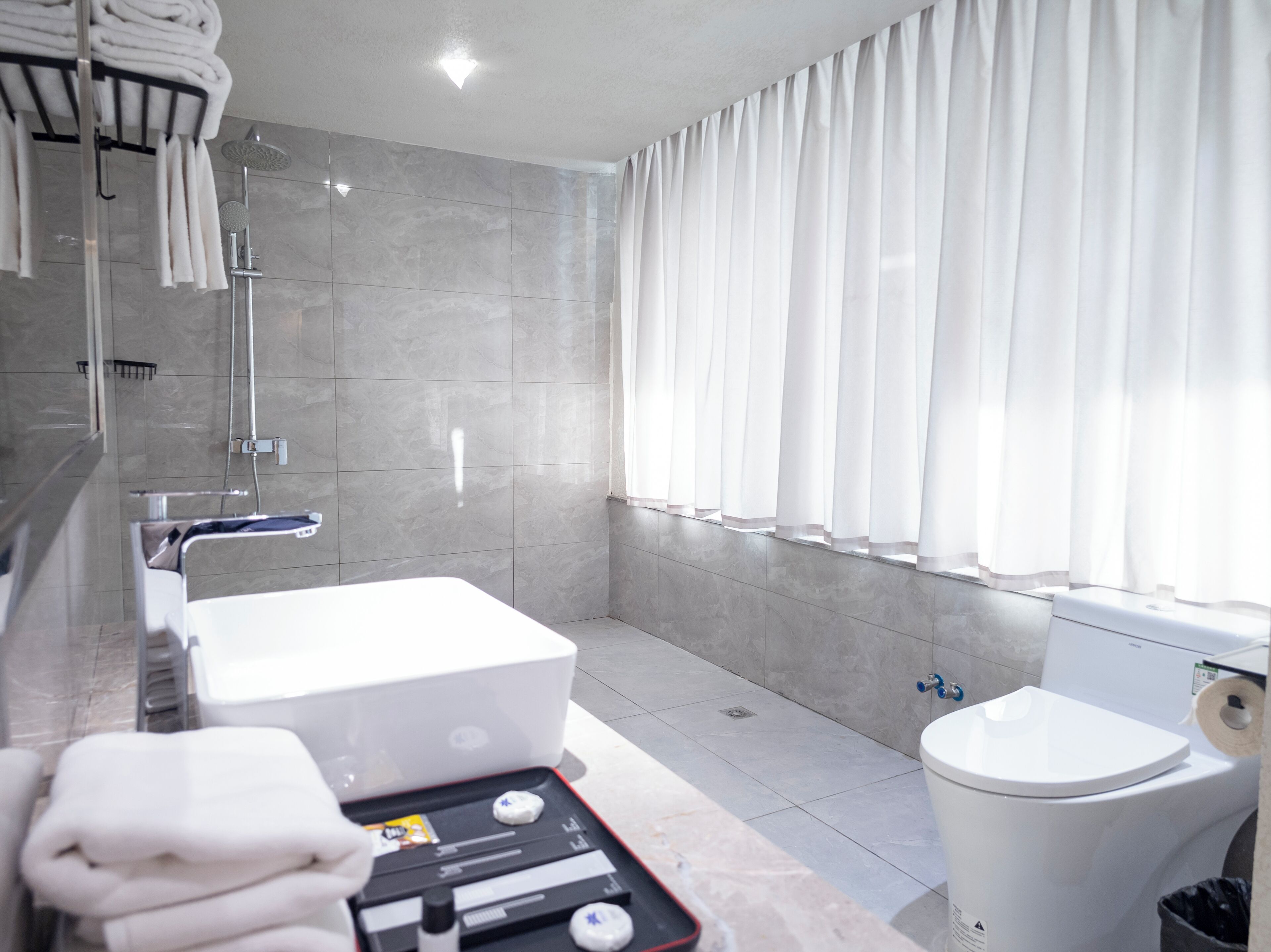 Ein modernes Badezimmer mit Badewanne, Toilette und Duschbereich.