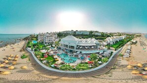 Un complexe hôtelier doté d’une piscine, d’une plage et de plusieurs bâtiments.