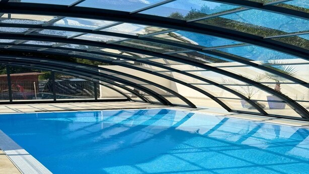 Una piscina con techo de vidrio.