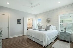 A bedroom with a bed, bedside table, and a door leading to a bathroom.
