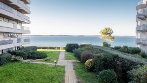 A residential building with a view of the sea, a pathway, and well-maintained greenery. - Quo Vadis - Proche plage et parking privé (Arcachon)