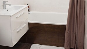 Un baño con lavamanos blanco, inodoro y bañera.