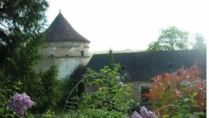 A historic building with a conical tower and a stone wall. - Le Pigeonnier (Plazac)