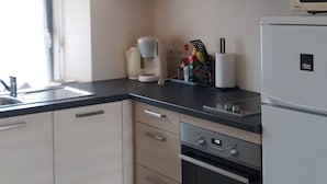 Una cocina con estufa, horno, microondas y armarios.