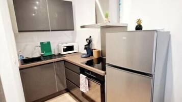 Eine kleine Küche mit Mikrowelle, Herd und Kühlschrank.
