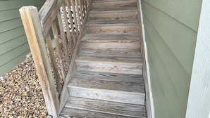 A wooden staircase with a handrail leading to a door marked with the number 12.
