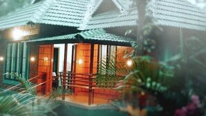 A traditional house with a tiled roof, a porch, and a staircase leading to the entrance. - Entire Villa at the Heart of the Wayanad Forest. (Thirunelly)