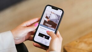 Een smartphone waarop een 'Guest Guide' voor een hotel wordt weergegeven.
