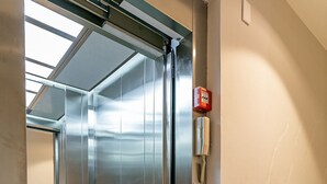 An elevator with a metallic interior, a visible emergency phone, and a control panel. - New studio near Beiramar Shopping #HKS14 (Florianópolis)