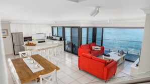 Un appartement moderne comprenant une cuisine, un coin repas et un salon avec un canapé rouge.