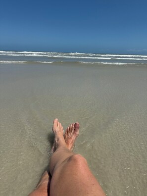 A beach scene with a clear view of the ocean and waves.