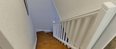 A staircase with wooden steps and white railings.