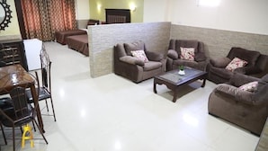 Uma sala de estar com sofá, mesa de centro e área de jantar com mesa e cadeiras.
