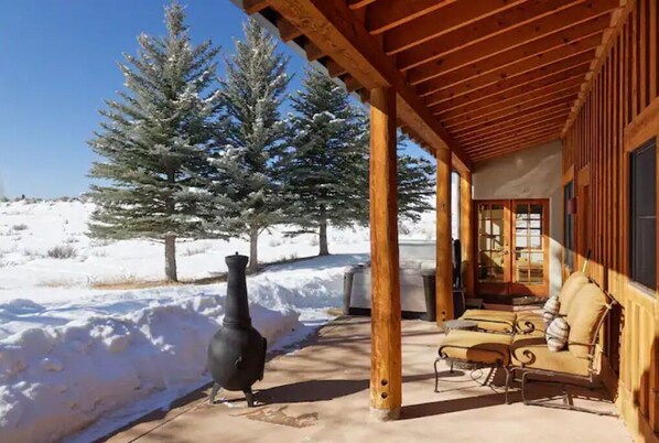 Relax in the serene outdoor patio, complete with a cozy stove and comfortable seating area.