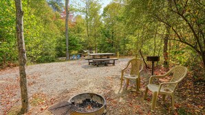 A campsite with a fire pit, picnic table, and chairs. - RV Site 4 of 4: Lot rental only; RVs not provided. (South Bloomingville)
