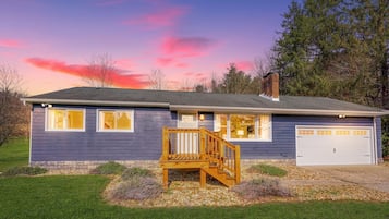 Stunning two-story home with a charming front porch and beautifully manicured lawn.