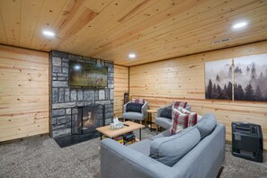 Una habitación acogedora con chimenea, televisión y una zona de estar confortable.