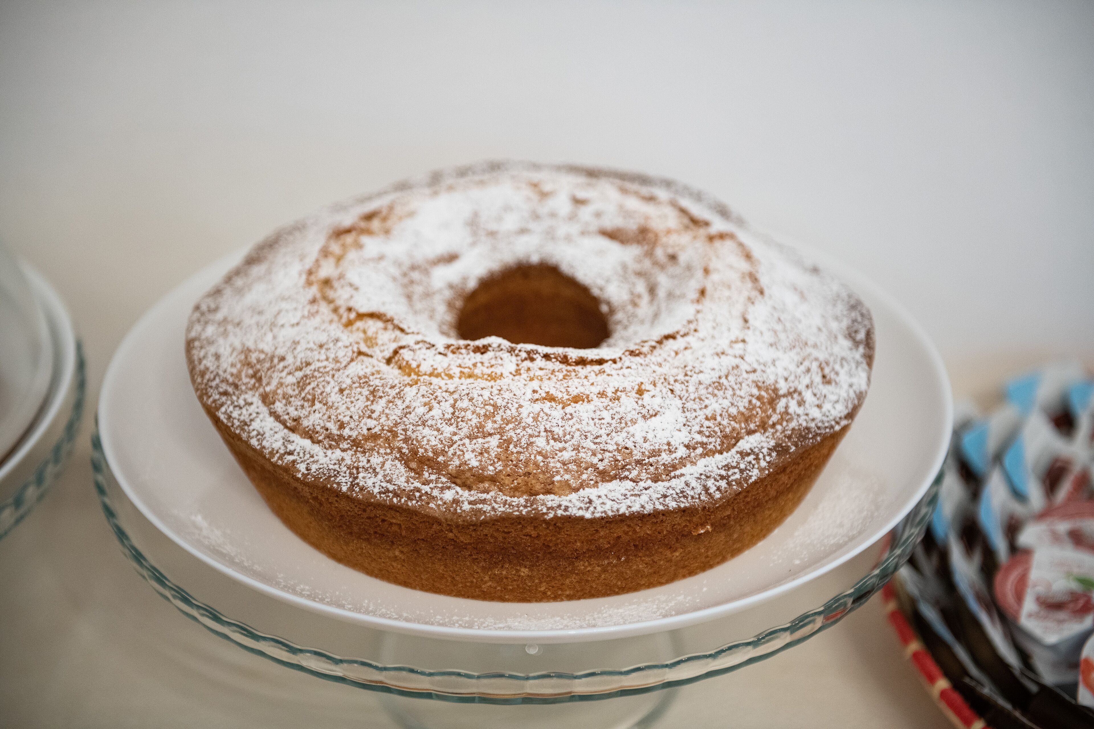 Een bundtcake op een transparante glazen taartplateau.
