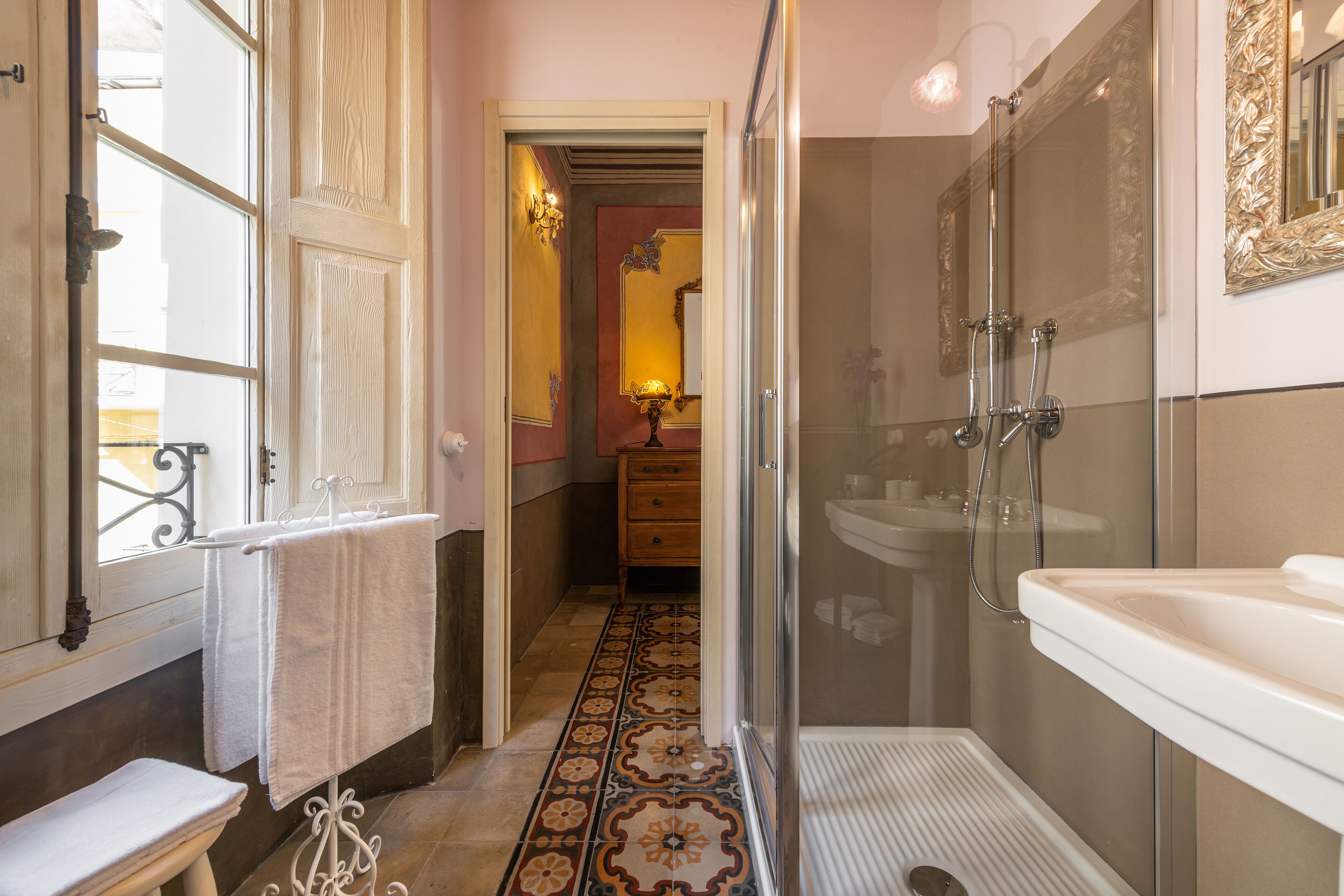 A bathroom with a shower, sink, and a vanity with a mirror.