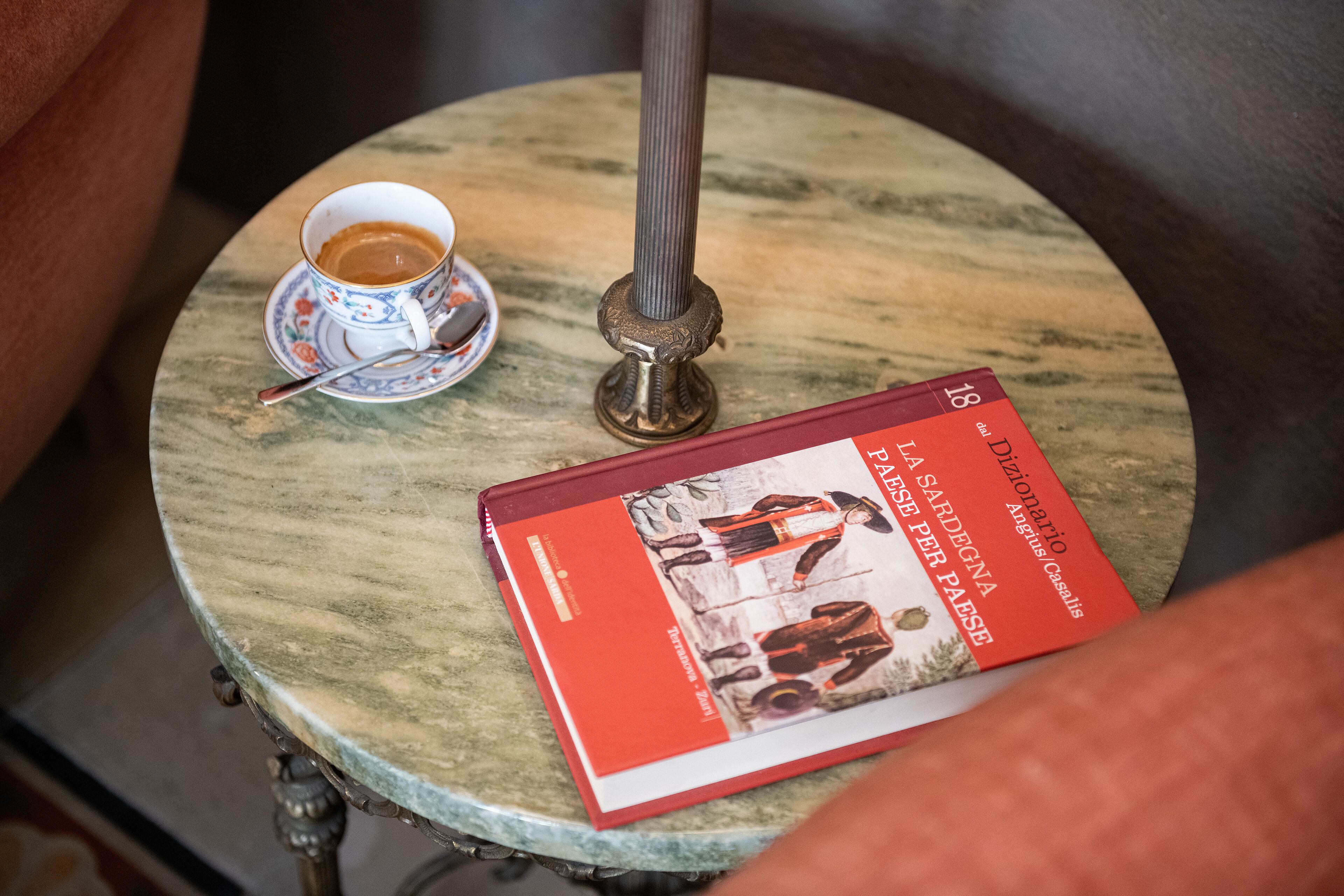 Una mesa redonda con un libro y una taza de café.