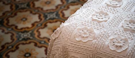 A close-up of a crocheted fabric with floral patterns and a detailed, textured surface.