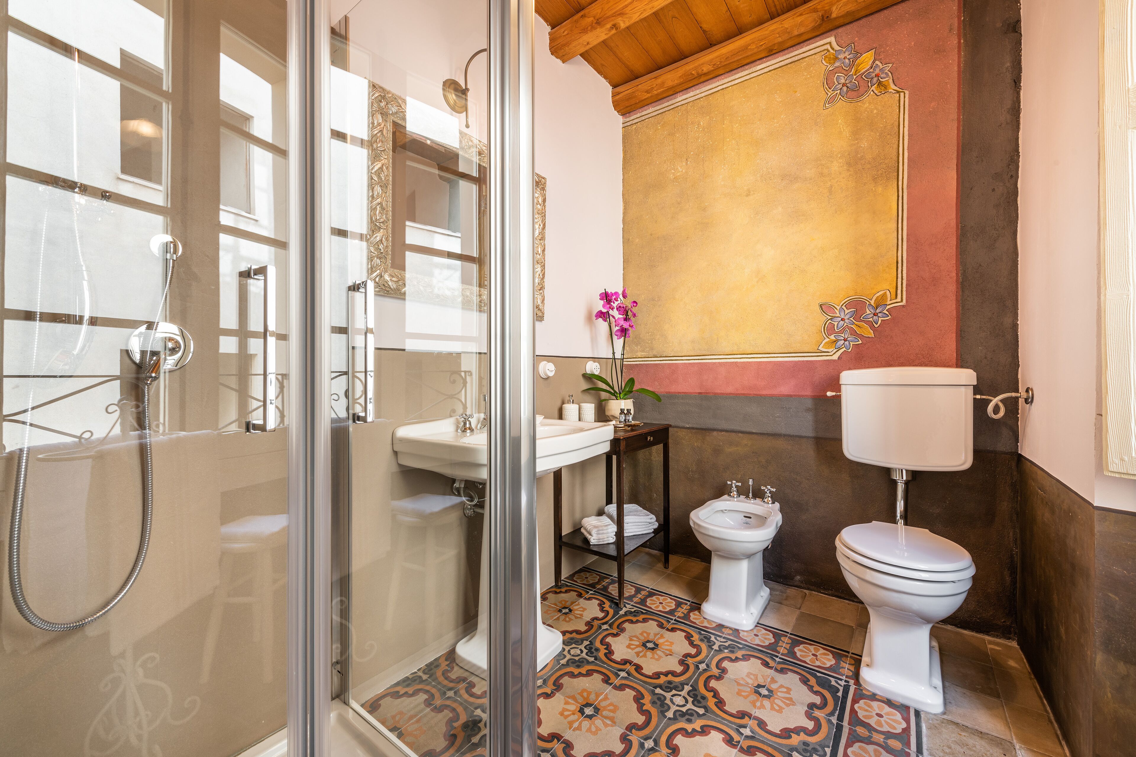 Un baño con ducha envuelta en vidrio, lavamanos, inodoro y bidé.
