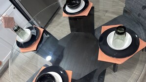 A circular glass table with three black and white coffee tables, each with a black base and a white top.