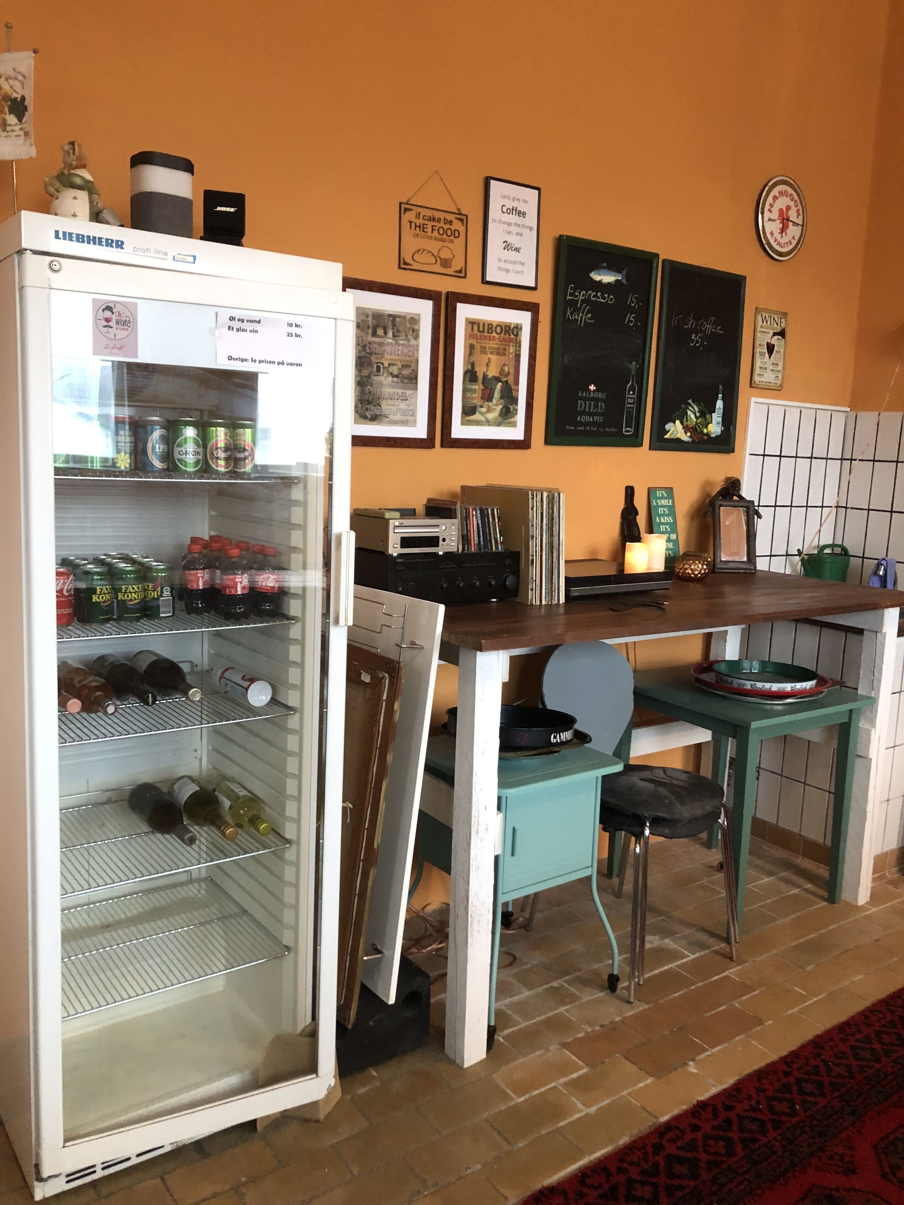 Una cocina con un refrigerador Liebherr, una cafetera y diversos alimentos en estantes.