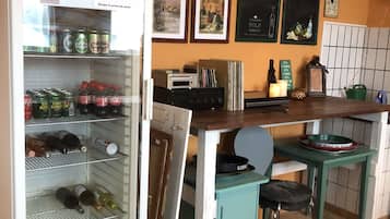 Una cocina con un refrigerador Liebherr, una cafetera y diversos alimentos en estantes.