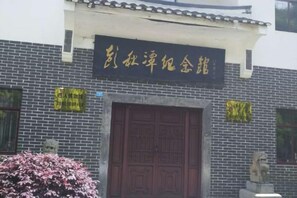 A building with a traditional Chinese architectural style, featuring a large wooden door and a signboard above it. - Lingyue Hotel (Changyang)