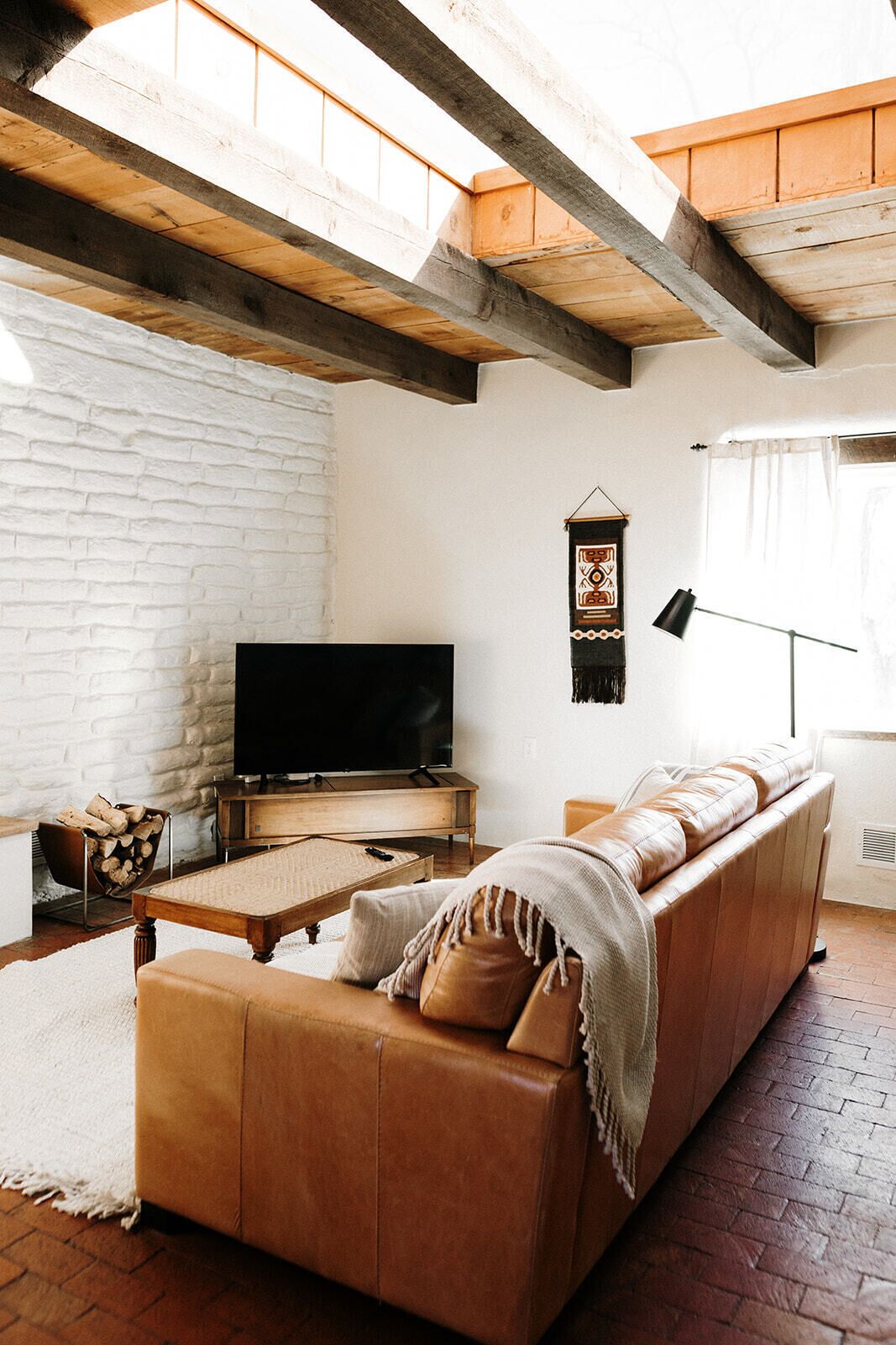 Ein gemütliches Wohnzimmer mit einer Holzdirektiva, einem Fernseher und einem Kamin.
