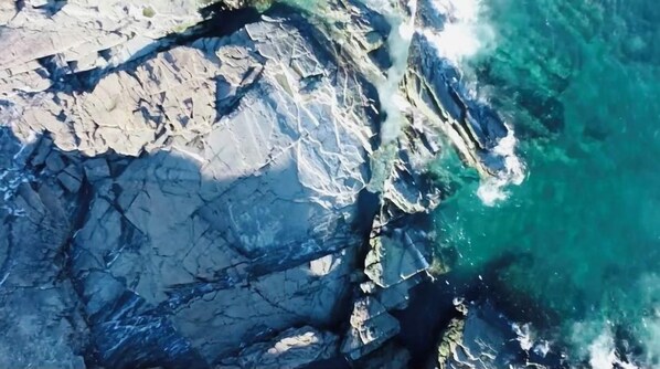 Una costa escarpada con acantilados rocosos y agua azul cristalina.