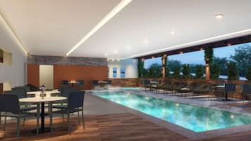 Uma área interna de piscina moderna com piso de madeira, cadeiras de sol e um espaço de refeições com mesas e cadeiras.