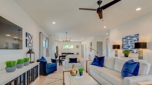 A modern living room with a sofa, coffee table, and decorative plants.